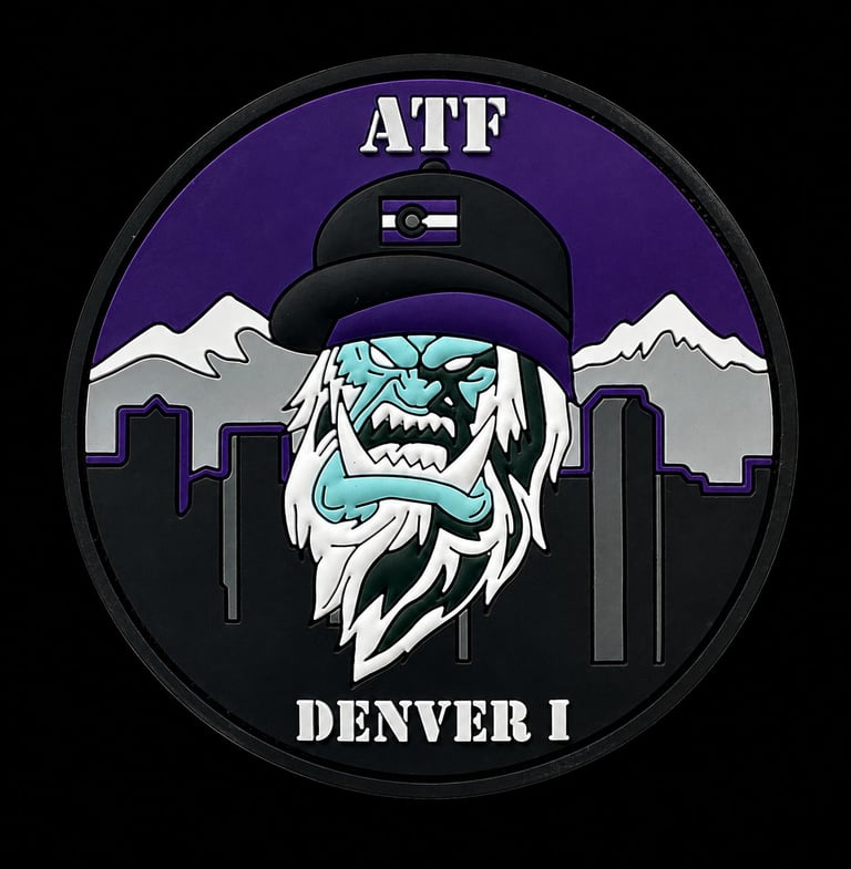 Circular embroidered organizational patch featuring a stitched character figure and city skyline on a black background